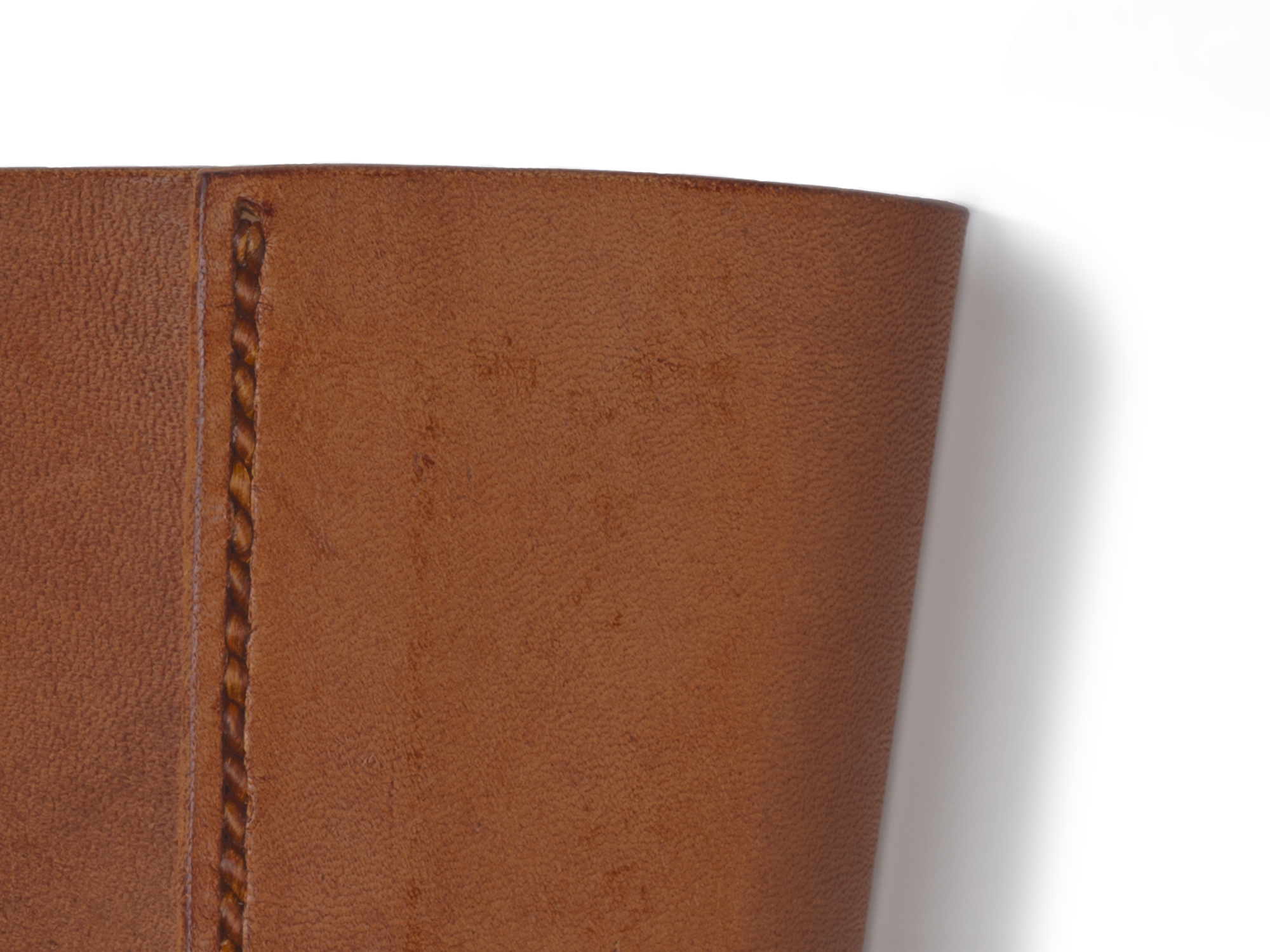 A technique established in 1919.<br />
Cup sleeves made from cowhide tanned using multiple processes.